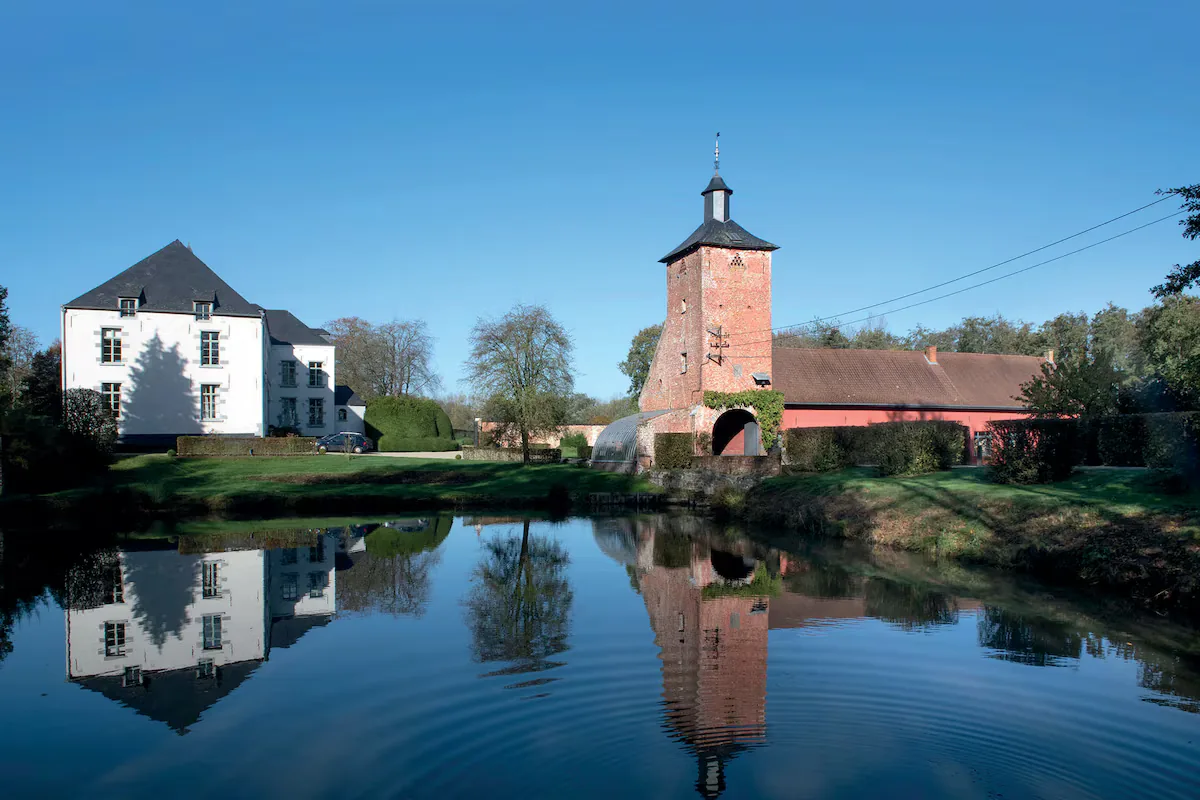 Château de Silly et sa tour en briques se reflétant dans un plan d'eau, patrimoine bâti de la commune