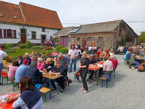 Convives attablés en plein air lors de la Balade des Saveurs devant une ferme de Silly