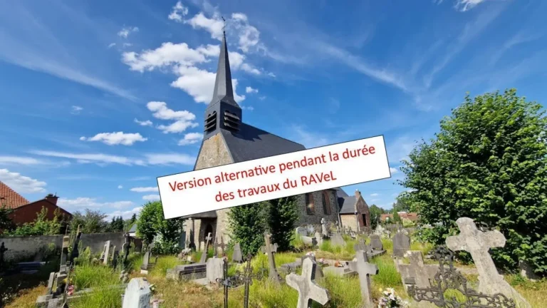 Église au clocher d'ardoise et ancien cimetière aux croix de pierre, avec la mention « Version alternative pendant la durée des travaux du RAVeL »