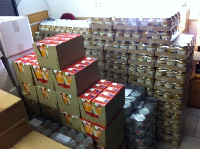 Stock d'aide alimentaire : conserves, bocaux et denrées dans un local de stockage du CPAS