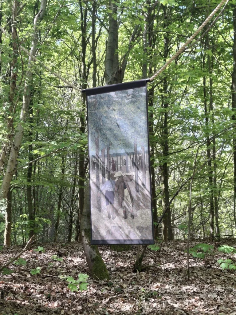 Grande reproduction de tableau aux tons gris-bleu suspendue entre les arbres du bois