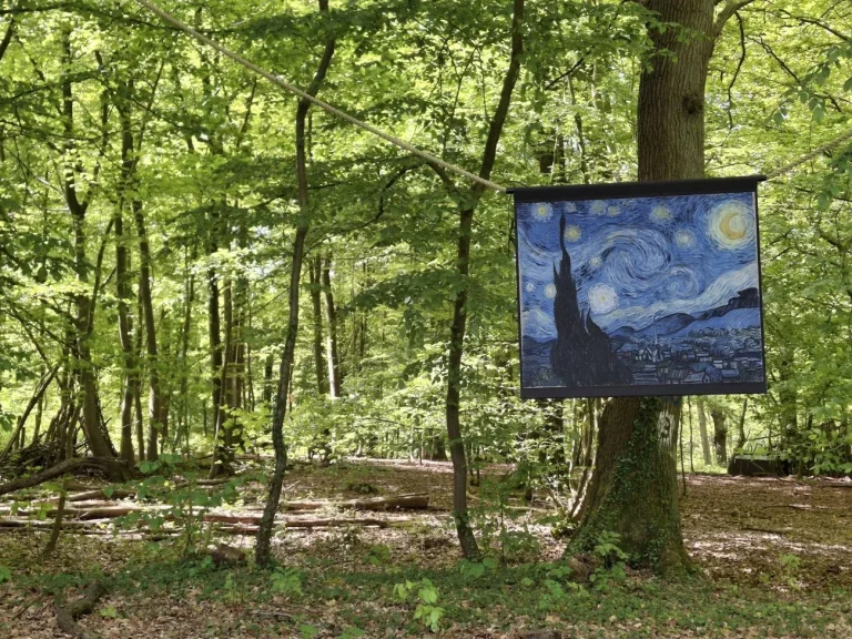 Reproduction de La Nuit étoilée de Van Gogh suspendue à une corde dans le sous-bois