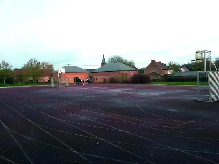 La plaine omnisports de Thoricourt : piste d'athlétisme avec l'église du village en arrière-plan